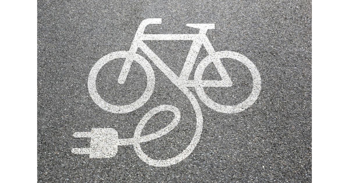 A pavement marking of an electric bicycle with a plug symbol, indicating an electric bike charging station or lane.