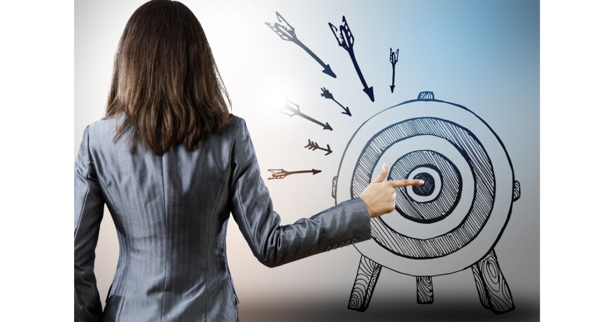 A businesswoman pointing at a target with arrows surrounding it, symbolizing goal-setting, focus, and striving for success in professional or personal endeavors.