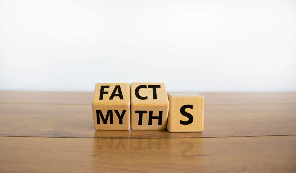 Wooden blocks displaying the words "FACTS" and "MYTHS" on a wooden surface, symbolizing the idea of distinguishing truth from misconceptions.