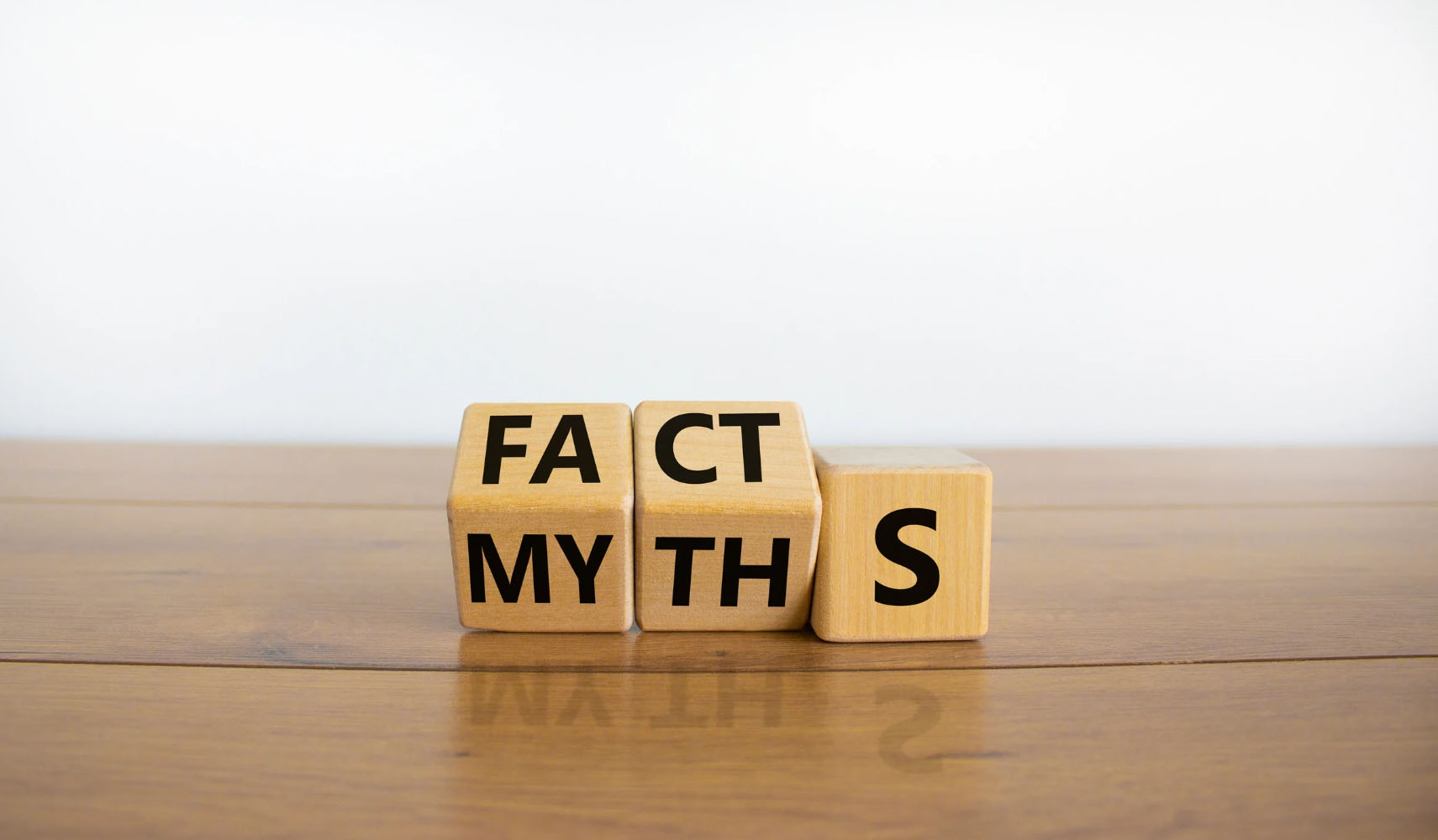 Wooden blocks displaying the words "FACTS" and "MYTHS" on a wooden surface, symbolizing the idea of distinguishing truth from misconceptions.
