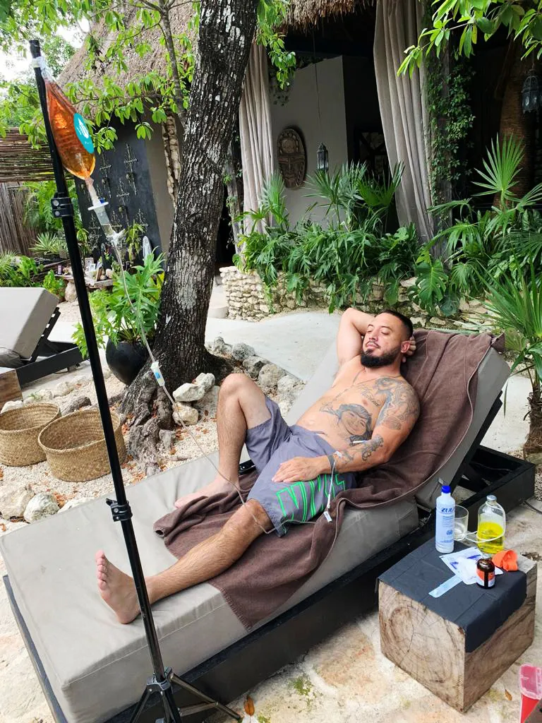 Male Relaxing at the Beach While Enjoying Viva Wellness IV Drip