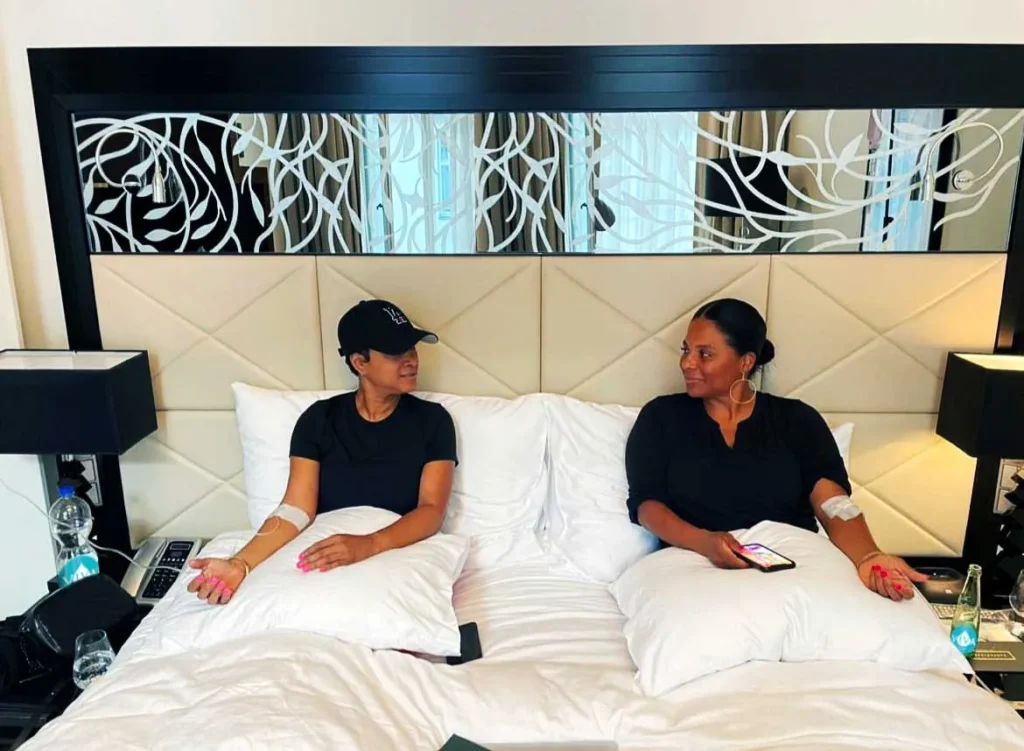 Men and women sitting on the bed.