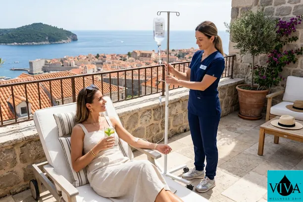 A mobile IV drip hydration session being administered to a traveler on a sunlit balcony with a panoramic view of the Split Riva and Diocletian's Palace in Croatia.